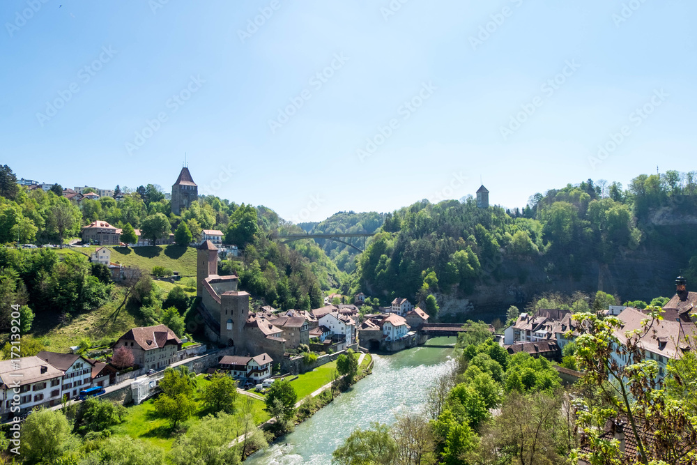 Fototapeta premium Cityscape of Fribourg town at Switzerland. There is Pont de Berne, ancient wooden bridge across river in image.