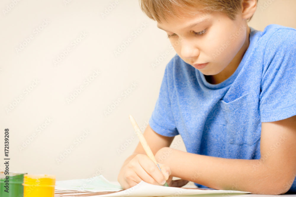 Boy painting with paintbrush and colorful gouache and watercolor paints. Boy painting with paintbrush and colorful gouache and watercolor paints.