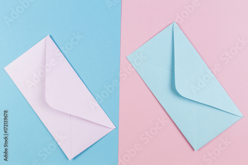 Pink and blue envelopes on colored pink and blue background. Top view.