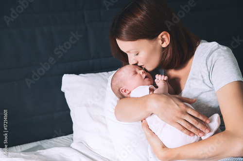 Sleeping baby in hands of his loving mother.