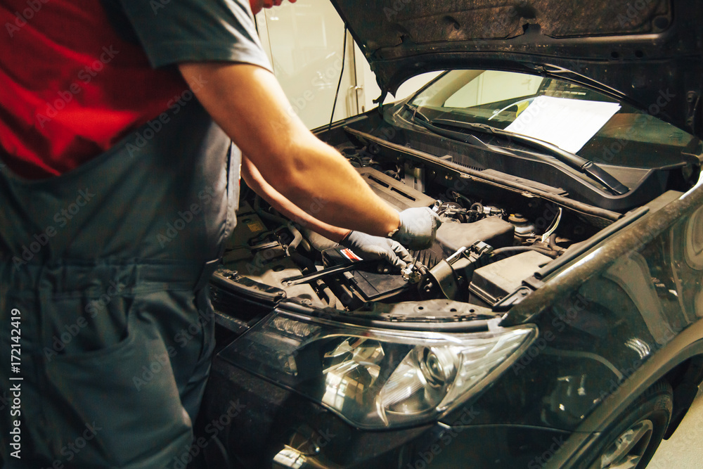 Car engine repair. An auto mechanic fixing an engine