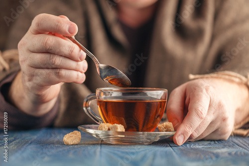 Hot tea in glass cup in male hands