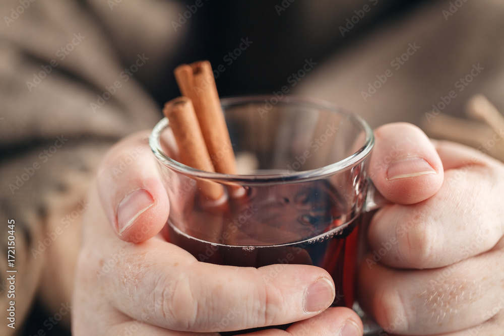 Homemade hot spiced wine in hand, mulled wine Homemade hot spiced wine in hand, mulled wine