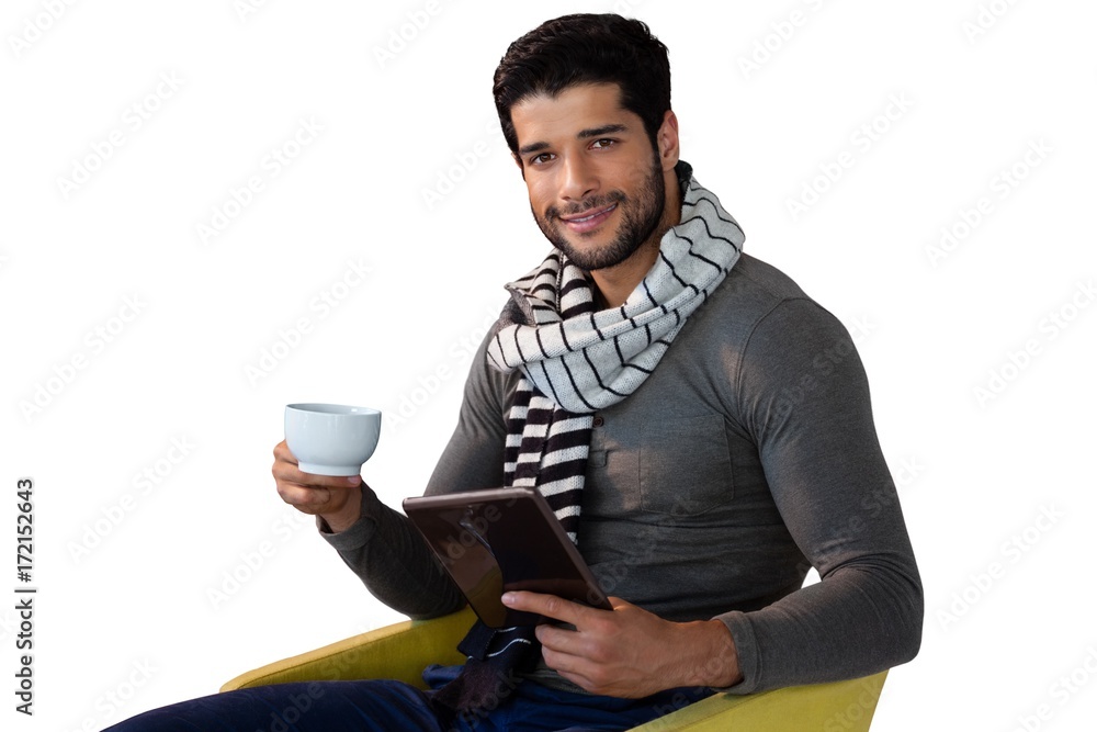 Portrait of man using digital tablet while having cup of tea Portrait of man using digital tablet while having cup of tea