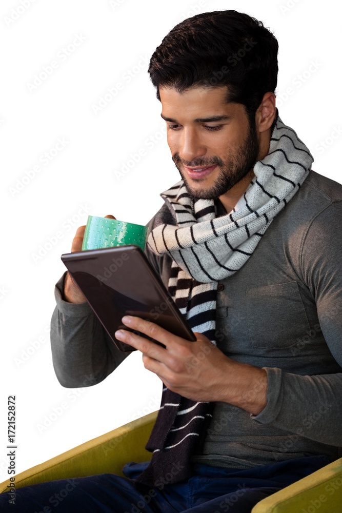 Man using digital tablet while having cup of tea Man using digital tablet while having cup of tea