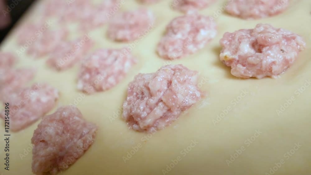 puts the stuffing on the dough carefully with a spoon close-up puts the stuffing on the dough carefully with a spoon close-up
