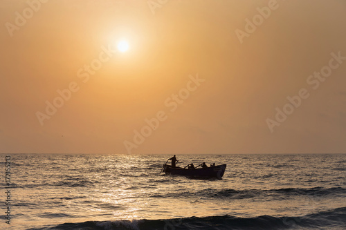 Fishermen silhouettes on boat, at sunrise © alexionutcoman