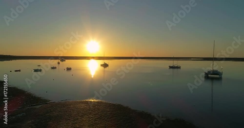 Sunrise aerial seascape, in Ria Formosa wetlands natural park, shot over Cavacos beach. Algarve.