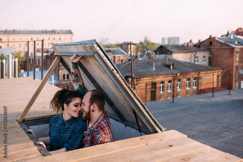 Love couple. Romantic date on roof. Creative leisure time, movie scene. Happy and young smiley people in focus on foreground, urban background