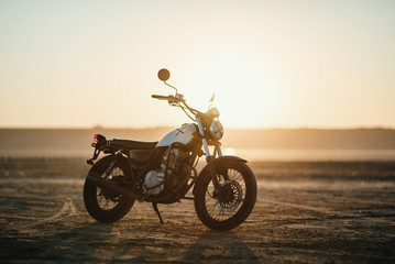 Tableau sur plexiglas Moto Café racer vintage désert au crépuscule  © tol_u4f