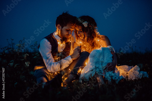 Beautiful bride and groom on a meadow at night. © Halfpoint