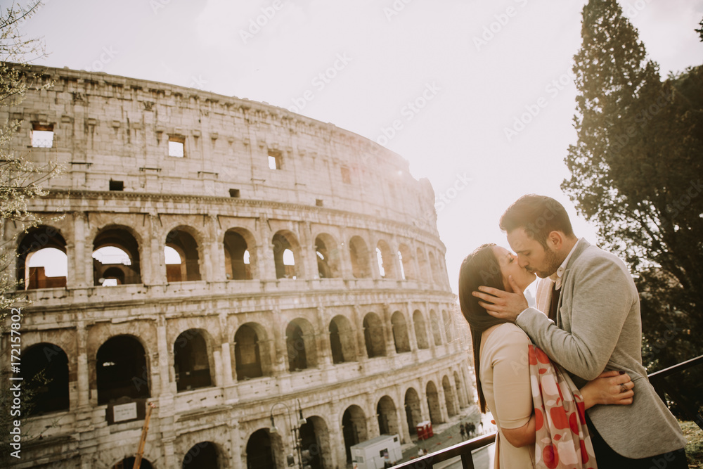Loving couple visiting Italian famous landmarks Colosseum in Rome, Italy