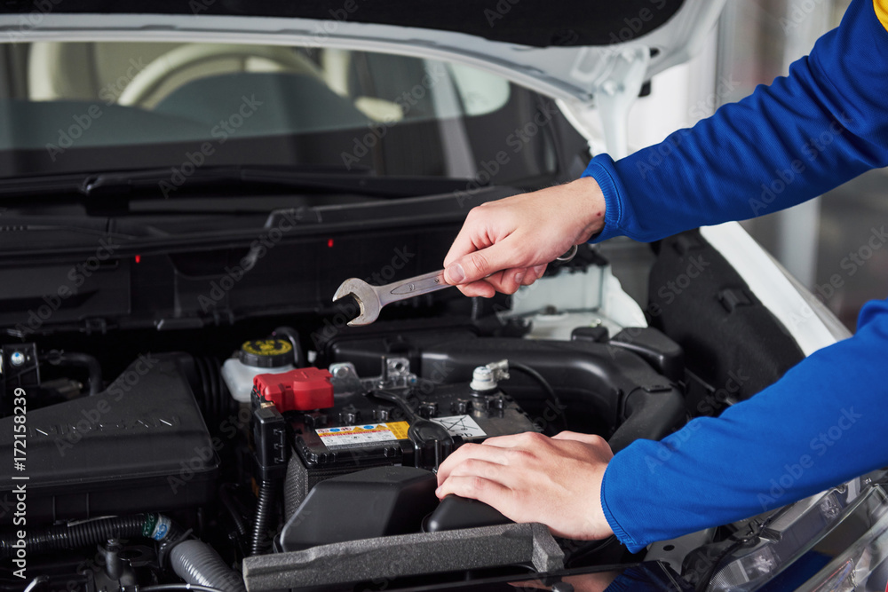Hands of car mechanic with wrench in garage. Hands of car mechanic with wrench in garage.
