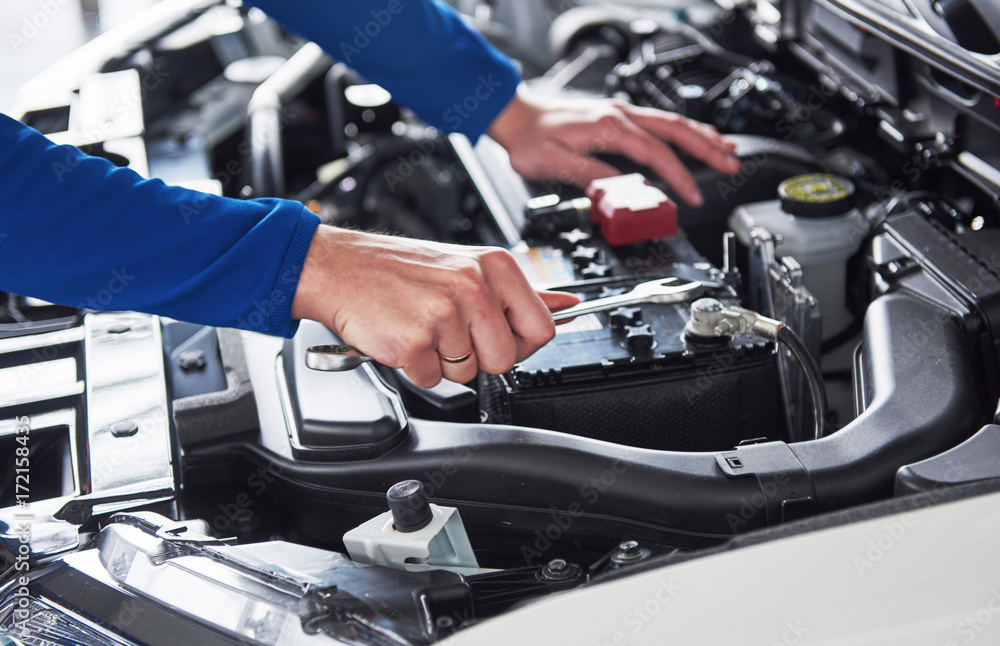 Hands of car mechanic with wrench in garage Hands of car mechanic with wrench in garage