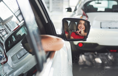 woman in car indoor keeps wheel turning around smiling looking at passengers in back seat idea taxi driver against sunset rays Light shine sky Concept of exam Vehicle - second home the girl