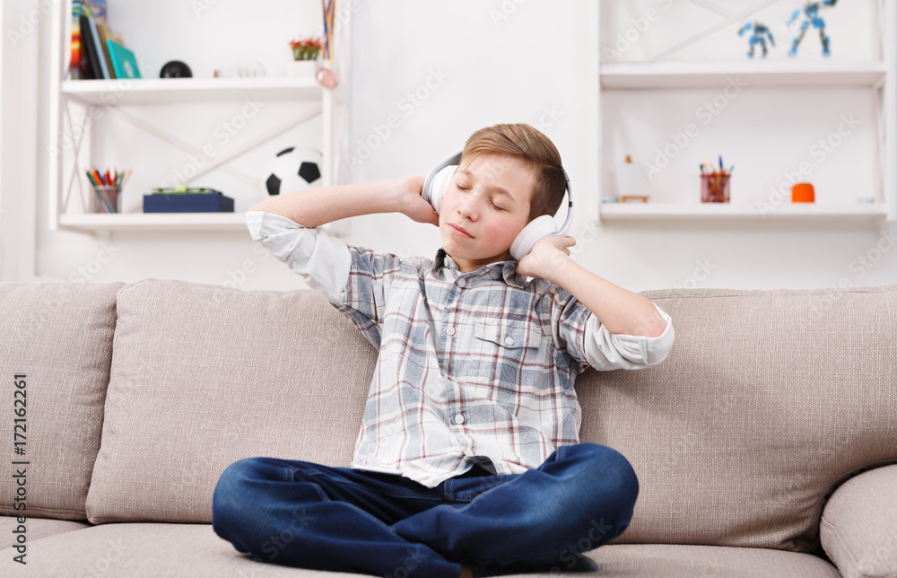 Teenage boy in casual enjoying music in headphones at home Teenage boy in casual enjoying music in headphones at home