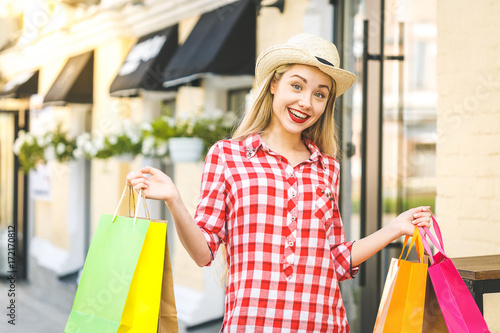 Portrait of young happy smiling woman. Young woman holding shopping bags. Online shopping concept.