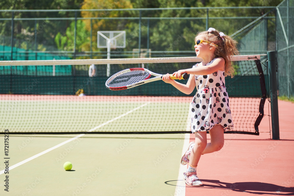 cute little girl playing tennis on the tennis court outside Stock Photo |  Adobe Stock