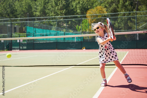 Cute girl playing tennis and posing for the camera © standret