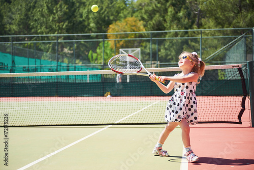Cute girl playing tennis and posing for the camera © standret
