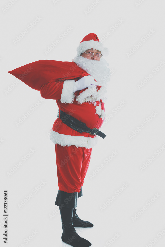 Real Santa Claus carrying big bag full of gifts, isolated on white background Real Santa Claus carrying big bag full of gifts, isolated on white background
