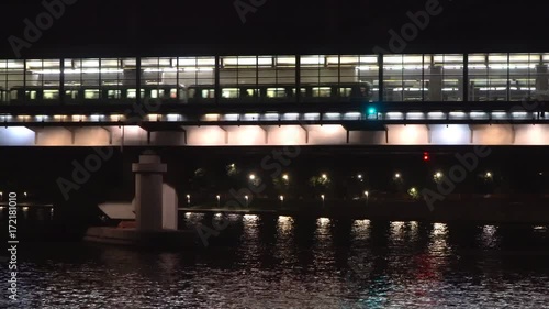 arrival and departure of subway train on the station located on the bridge over the river