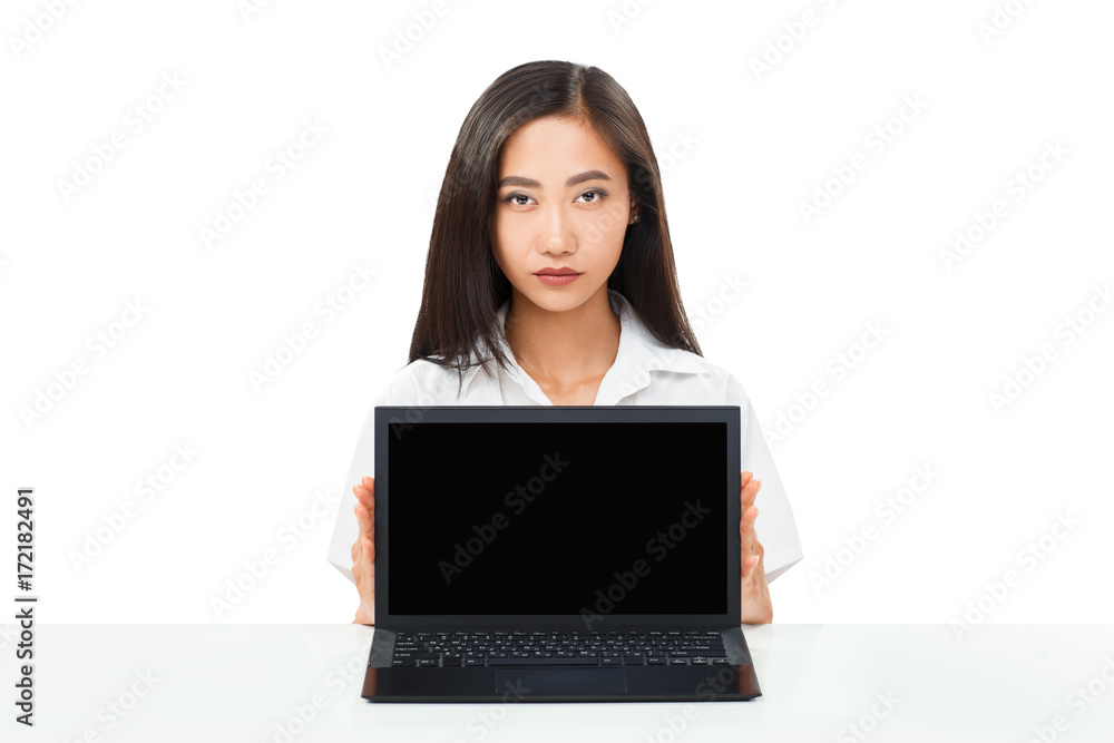 Serious Asian woman sitting with laptop with black blank screen Serious Asian woman sitting with laptop with black blank screen