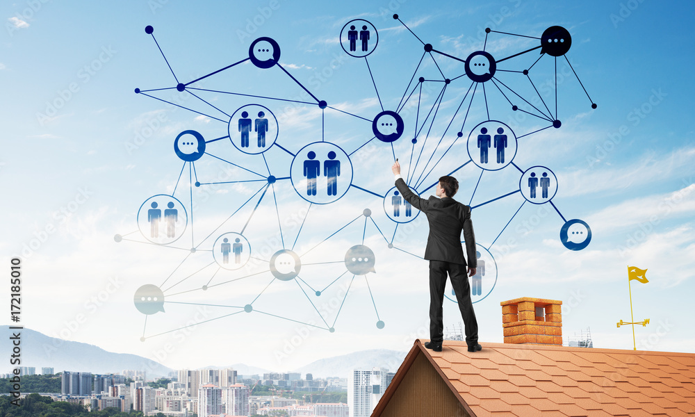 Businessman on house roof presenting networking and connection concept. Mixed media Businessman on house roof presenting networking and connection concept. Mixed media