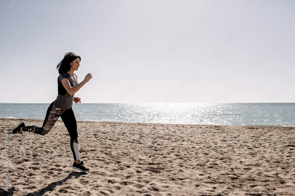beautiful girl with sports forms sports on the beach, drinking water, jumping, running, doing different exercises beautiful girl with sports forms sports on the beach, drinking water, jumping, running, doing different exercises