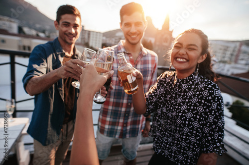 Friends toasting drinks on a rooftop © Jacob Lund