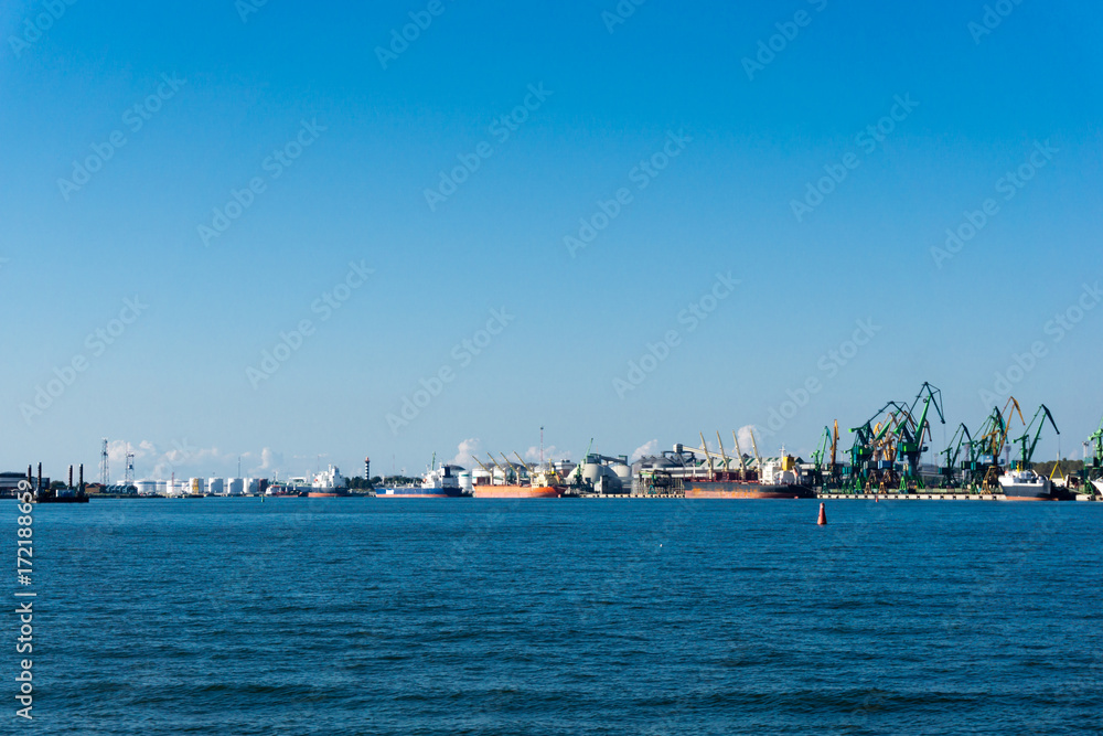 Loading cranes and ship at Baltic sea in sea Port, Klaipeda, Lithuania. Sunset
