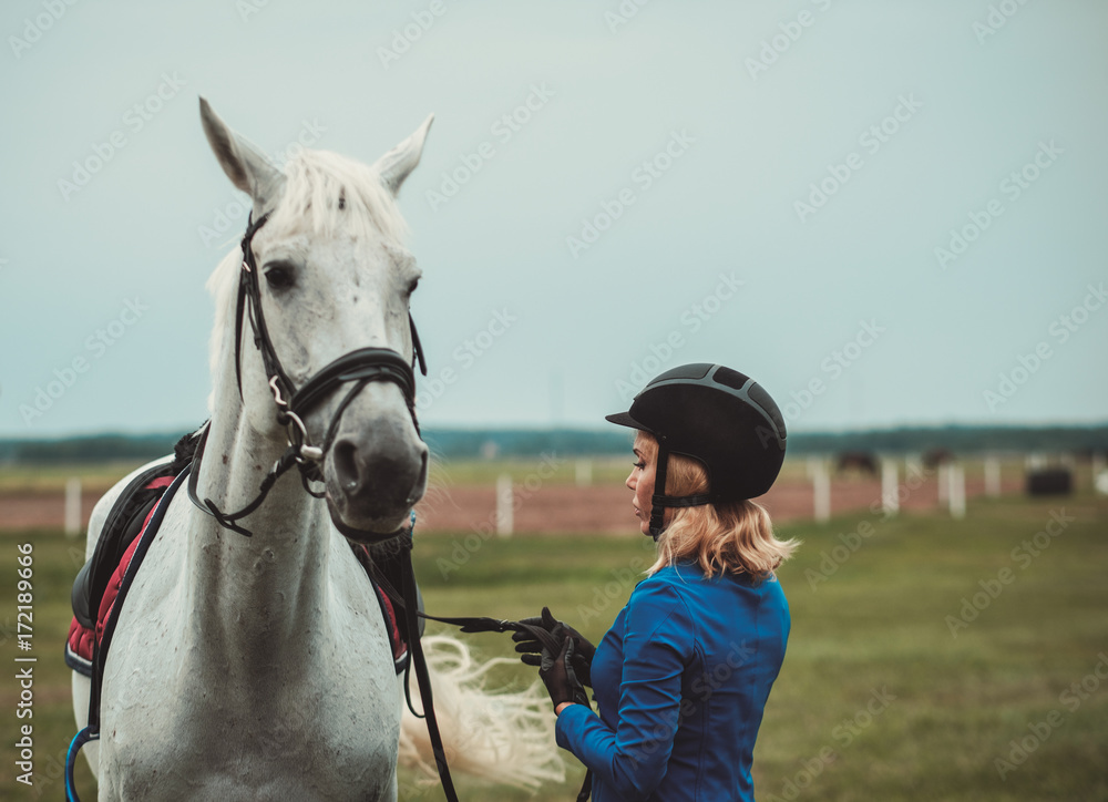 Obraz premium Middle-aged woman with her horse outdoors
