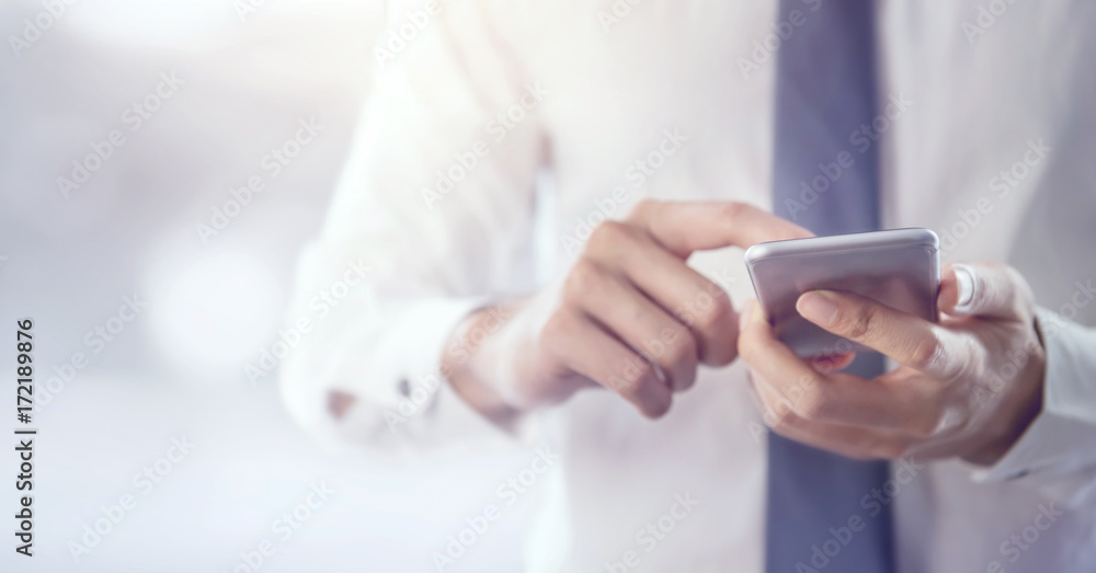 Fototapeta premium Close up of a business man using mobile smart phone, copy space.