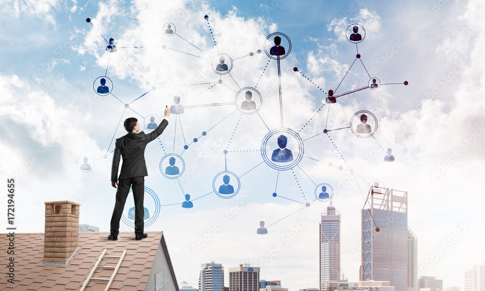 Businessman on house roof presenting networking and connection concept. Mixed media Businessman on house roof presenting networking and connection concept. Mixed media