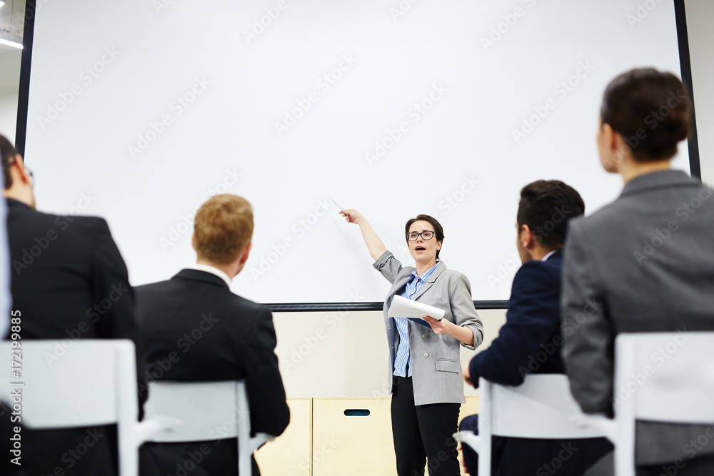 Intelligent businesswoman explaining her audience methods of financial increase, income and prosperity Intelligent businesswoman explaining her audience methods of financial increase, income and prosperity