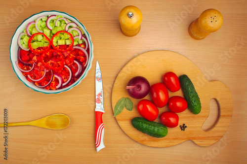 salad of cucumber and tomato cooking, spoon and knife