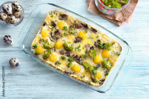 Baking dish with broccoli casserole on wooden table