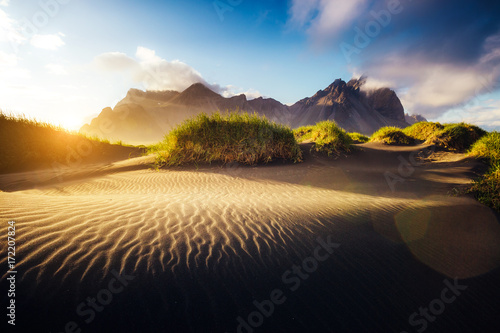 Beautiful view of the yellow hills glowing by sunlight. Location place Stokksnes cape, Vestrahorn, Iceland, Europe.