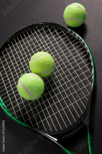 High angle view of fluorescent yellow tennis balls and racket © WavebreakMediaMicro