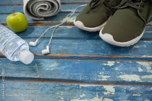 High angle view of sports shoes and napkin by headphones with
