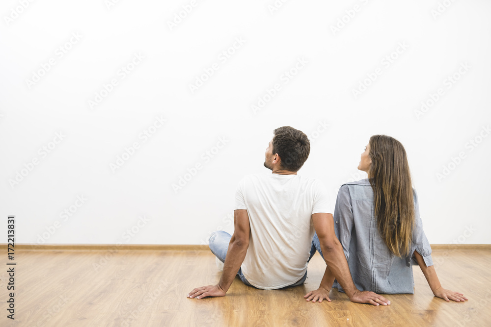 The sitting couple look the empty wall The sitting couple look the empty wall