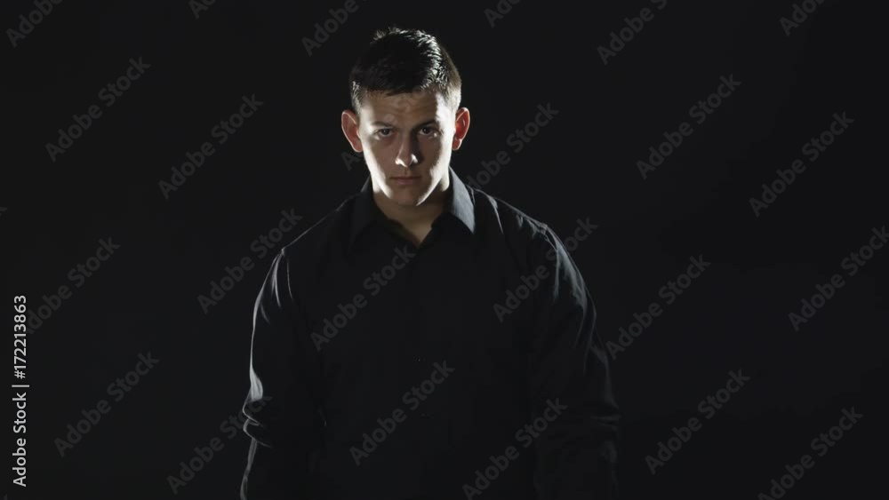 Slow motion man with black shirt and black background Slow motion man with black shirt and black background