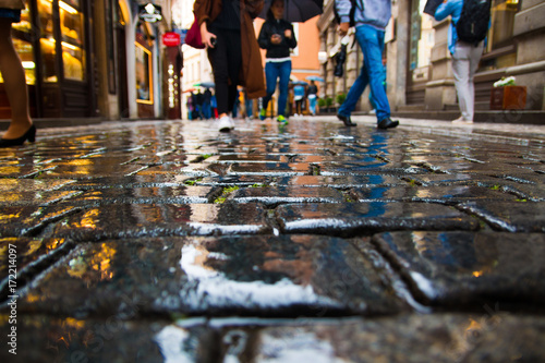 People walking on wet paving stones in rainy day in old town of Prague © dtatiana