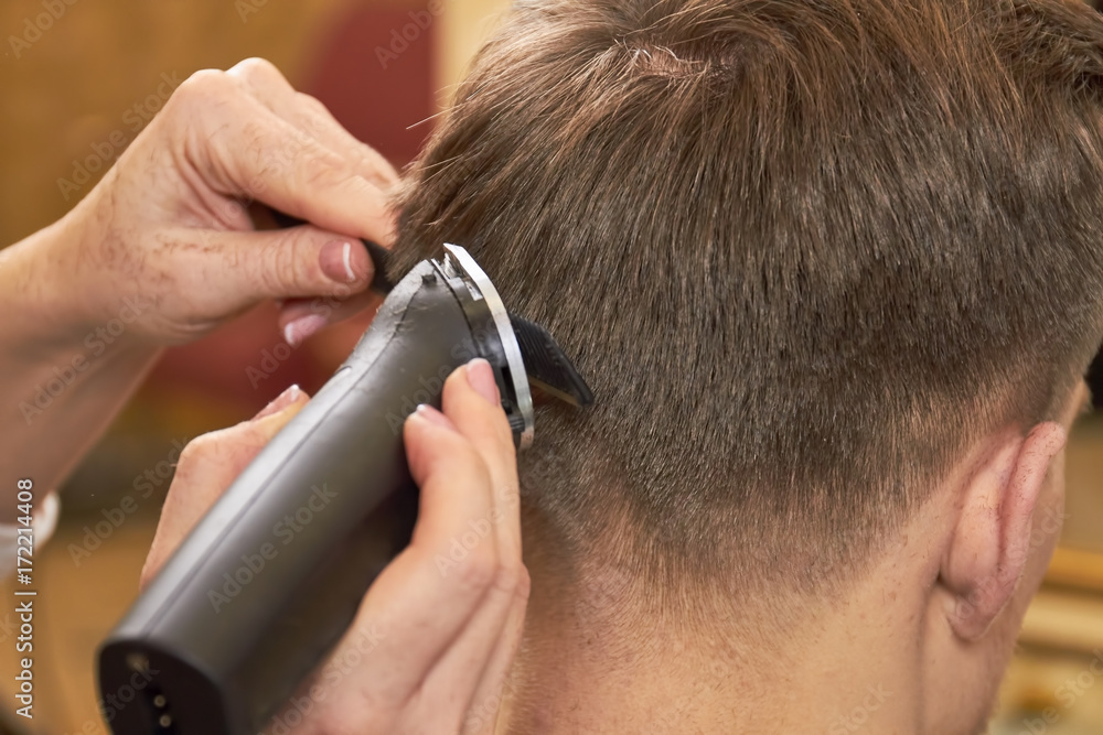 Man getting haircut, close up. Comb and hair clipper.