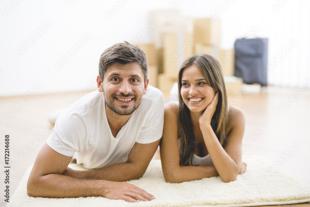 The happy couple lay on the carpet The happy couple lay on the carpet