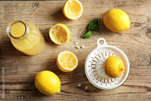 Composition with lemon juice and squeezer on wooden background