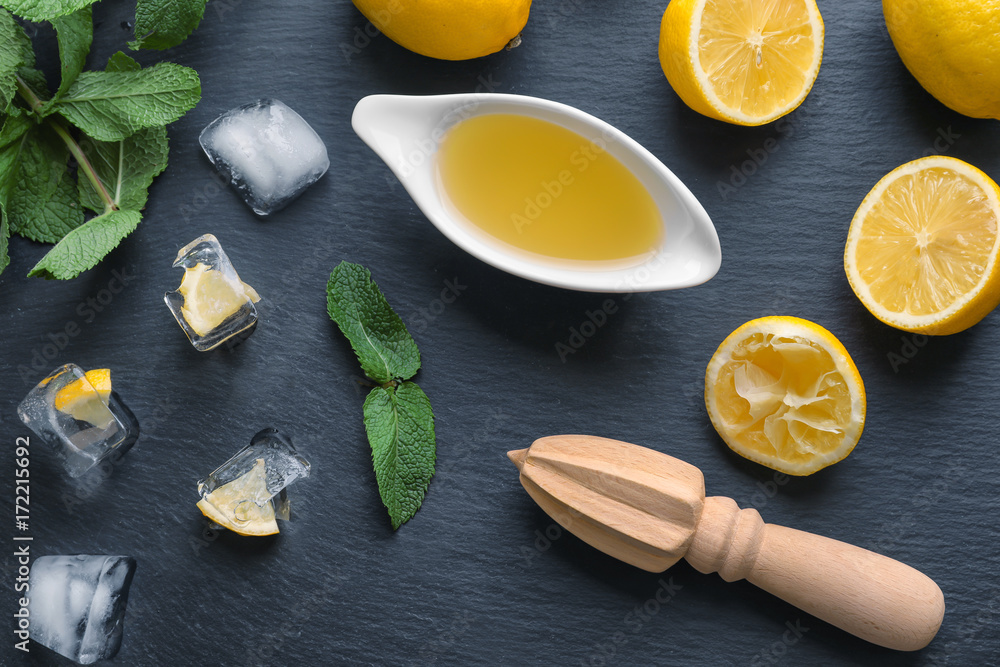 Composition with lemon juice, ice and squeezer on table