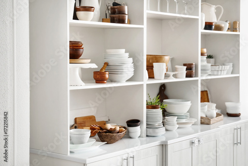 White storage stand with ceramic and wooden dishware in kitchen