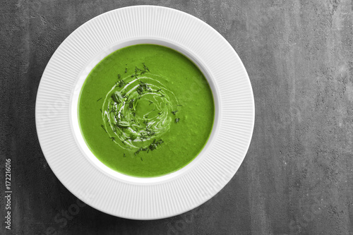 Plate with tasty spinach soup on table