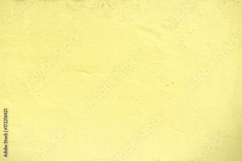 Textures of pastel yellow painted grunge concrete background